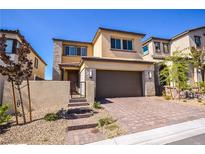 Inviting two-story home featuring a two-car garage and stylish stone accents at 12101 Arrebol Ave, Las Vegas, NV 89138