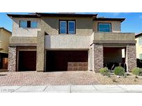 Inviting two story home with a three-car garage and brick paved driveway and an easy to care landscape at 1288 Ventura Cliffs Ave, Henderson, NV 89012