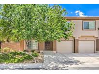 Charming townhouse with a well-manicured lawn, a mature shade tree, and a two-car garage at 1605 Colloquium Dr, Henderson, NV 89014