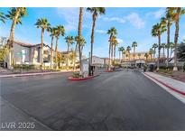 A gated community entrance with lush landscaping and mature palm trees creates a welcoming environment at 2615 W Gary Ave # 2013, Las Vegas, NV 89123