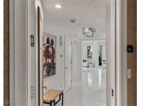 Bright hallway featuring white tile floors, modern lighting, and elegant artwork, leading to a comfortable living space at 2857 Paradise Rd # 305, Las Vegas, NV 89109