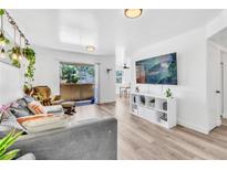 Bright living room featuring modern decor, laminate flooring, and a sliding glass door to the balcony at 3151 Soaring Gulls Dr # 2136, Las Vegas, NV 89128