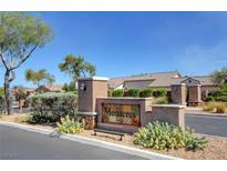 A stone community sign is surrounded by desert landscaping and lush greenery in the Monterey neighborhood at 9431 Borough Park St, Las Vegas, NV 89178