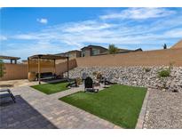 Inviting backyard featuring a pergola, fire pit area with chairs, and low-maintenance landscaping at 9641 Rankin Ridge Ct, Las Vegas, NV 89178