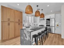 Modern kitchen with stainless steel appliances, island with seating, and stylish pendant lighting at 10613 Turquoise Valley Dr, Las Vegas, NV 89144