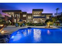 Stunning backyard oasis featuring a large pool, lounge seating and landscaped grounds of this modern home at 1472 Macdonald Ranch Dr, Henderson, NV 89012