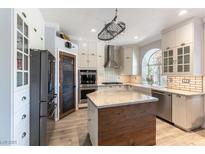 Bright kitchen with wooden floors, stainless steel appliances, and white cabinets at 2434 Amoretti St, Henderson, NV 89052