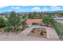 Stunning single-story home with a circular driveway, well-manicured landscaping, and mature trees at 3065 S Torrey Pines Dr, Las Vegas, NV 89146