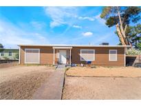 Single-story home with brown wood siding, front yard with desert landscaping, and walkway to the front door at 343 Tungsten St, Henderson, NV 89015