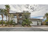 Beautiful two-story home with stone accents, manicured landscaping, palm trees, and a three-car garage at 5367 Secluded Brook Ct, Las Vegas, NV 89149