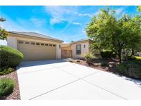 Inviting single-story home with attached two car garage, neutral color palette, and well manicured landscaping at 8236 Imperial Lakes St, Las Vegas, NV 89131