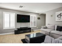 Bright living room with hardwood floors, plantation shutters, and a large sectional sofa at 10030 Trotter Peak St, Las Vegas, NV 89178