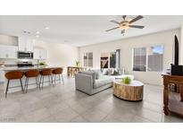 Bright open-concept living room featuring modern kitchen, breakfast bar, and comfortable seating area at 1783 Matteo Cove Pl, North Las Vegas, NV 89084