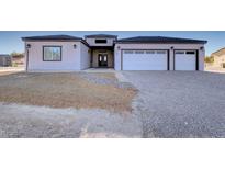 Charming single-story home features a double door entrance, a two car garage, and desert landscaping at 2660 S Blagg Rd, Pahrump, NV 89048
