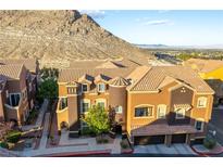 Stylish townhome featuring a 2-car garage, turret, desert landscaping, and mountain views at 3975 N Hualapai Way # 212, Las Vegas, NV 89129