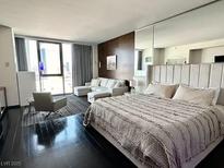 Modern bedroom featuring floor-to-ceiling windows, dark wood floors and a comfortable sitting area at 4381 W Flamingo Rd # 1504, Las Vegas, NV 89103