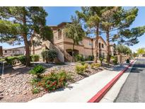 Condominium exterior featuring desert landscaping, mature trees, and walkway access at 5751 E Hacienda Ave # 105, Las Vegas, NV 89122