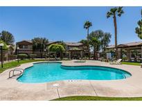 Community pool area with sparkling blue water, lounge chairs, and lush landscaping for relaxation and enjoyment at 5751 E Hacienda Ave # 105, Las Vegas, NV 89122