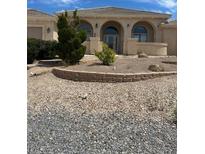 Charming home featuring an arched entry and low maintenance desert landscaping for an appealing and water-wise facade at 6841 Longmeadow Dr, Pahrump, NV 89061
