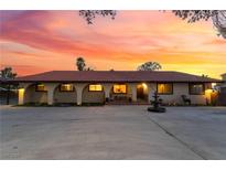 Expansive single story home boasts arched entryways and a water fountain, set against a vibrant sunset sky at 711 Sari Dr, Las Vegas, NV 89110
