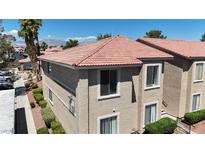 Tan two-story condo with a terra cotta colored roof and desert landscaping on a sunny day at 7200 Pirates Cove Rd # 2025, Las Vegas, NV 89145