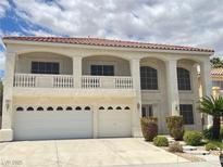 Stunning two-story home featuring a balcony, arched windows, and a three-car garage at 7851 Tidal Pool Ct, Las Vegas, NV 89139