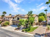 Inviting two-story home featuring well-manicured landscaping, a two-car garage, and solar panels on the roof at 8217 Fritzen Ave, Las Vegas, NV 89131