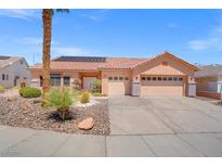 Charming single-story home with desert landscaping, a two-car garage and a terracotta tile roof with solar panels at 9624 Twelve Pins Dr, Las Vegas, NV 89129