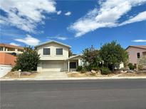 Charming two-story home featuring a well-maintained lawn, mature trees, and an attached two-car garage at 1021 Calico Ridge Dr, Henderson, NV 89011