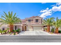 Charming stucco home with tile roof, three-car garage, and lush landscaping featuring mature palm trees at 11275 Gammila Dr, Las Vegas, NV 89141