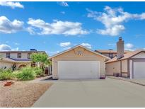 Charming home with a two-car garage and driveway, set against a bright, cloudy sky at 1676 Divinity St, Las Vegas, NV 89142