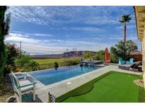 Beautiful backyard pool with golf area, mountain views, and blue skies at 19 Contrada Fiore Dr, Henderson, NV 89011