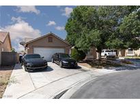 Charming single-story home with a two-car garage and well-maintained front yard and cars at 2631 Bed Knoll Ct, North Las Vegas, NV 89031