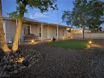 Charming home featuring a landscaped front yard with a cozy bench and decorative outdoor lighting at 419 National St, Henderson, NV 89015