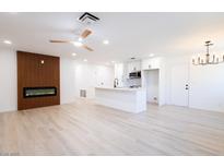 Open living room and kitchen featuring an electric fireplace, ceiling fan and white cabinetry at 508 S Jones Blvd, Las Vegas, NV 89107