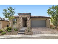 Charming single-story home with stone accents, a two-car garage, and landscaped front yard at 58 Sun Lily Ln, Henderson, NV 89011
