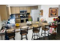 Eat-in kitchen features granite countertops, stainless steel appliances, and seating at the breakfast bar at 6429 Rosemount Ave, Las Vegas, NV 89156