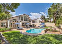 Beautiful backyard featuring a sparkling pool, lush lawn, and plenty of space for outdoor entertaining at 8320 Opal Cove Dr, Las Vegas, NV 89128