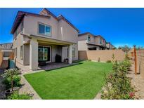 View of the well-kept backyard featuring a green lawn and a covered patio at 8898 Sasquatch Run Ave, Las Vegas, NV 89166