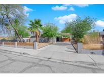 Charming single-story home with a landscaped front yard, driveway, and modern fence at 942 Westminster Ave, Las Vegas, NV 89119
