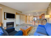 Bright living room with fireplace, TV, comfortable seating, and an adjacent kitchen space at 211 E Flamingo Rd # 620, Las Vegas, NV 89169