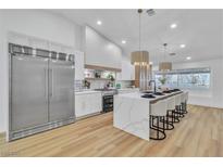 Bright kitchen featuring a large island, stainless steel appliances and modern pendant lighting at 3109 Siena Cir, Las Vegas, NV 89128