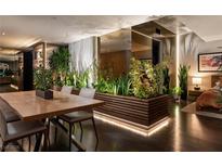 Stylish dining area featuring a wooden table, elegant chairs, and illuminated plant accents at 353 E Bonneville Ave # 1302, Las Vegas, NV 89101