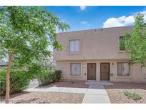 Inviting townhome featuring mature trees, secure windows, and individual front door access at 6299 W Washington Ave, Las Vegas, NV 89107
