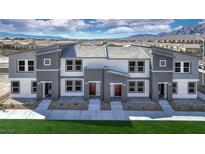 Modern townhome exteriors showcasing a gray and white color scheme and neat landscaping at 7384 Hayes Harbor Ct # Lot 213, North Las Vegas, NV 89084