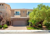 Charming two-story home featuring a brick-accented garage and balconies at 9823 Belle Marie Ct, Las Vegas, NV 89141