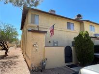 Charming two-story townhome featuring a stucco facade, arched entry gate, and an American flag at , Henderson, NV 89011