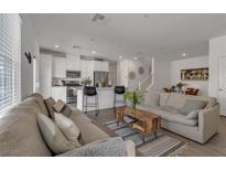 Bright living room featuring open floor plan to kitchen with modern appliances and breakfast bar seating at 236 Callen Falls Ave # 1211, Henderson, NV 89011