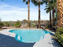 Inviting backyard pool surrounded by palm trees and desert landscaping at 2894 Matese Dr, Henderson, NV 89052