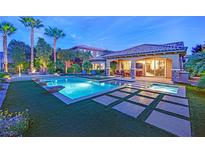 Stunning backyard pool with a spa, covered patio, and lush landscaping, perfect for outdoor relaxation and entertainment at 2901 Josephine Dr, Henderson, NV 89044